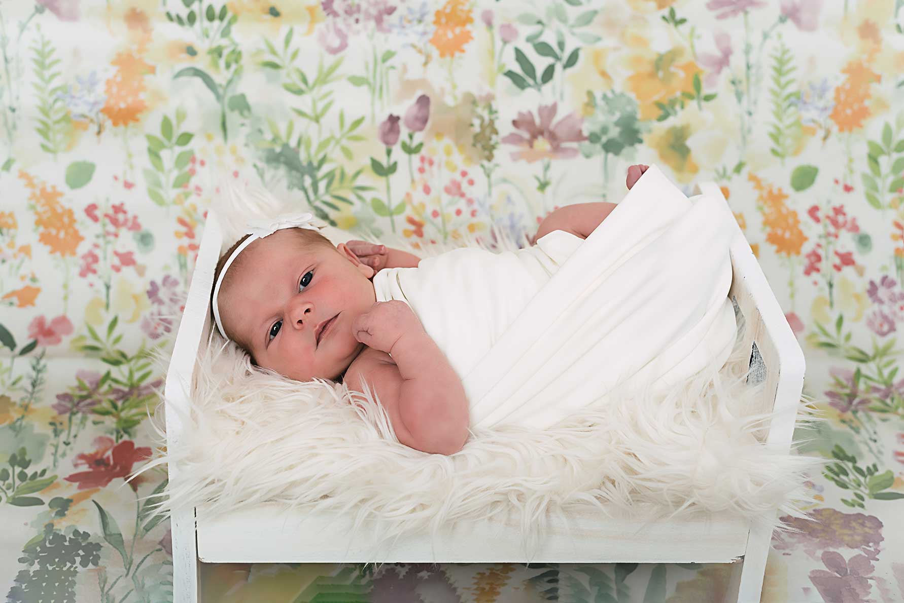 Newborn baby with wooden backdrop, studio shooting.